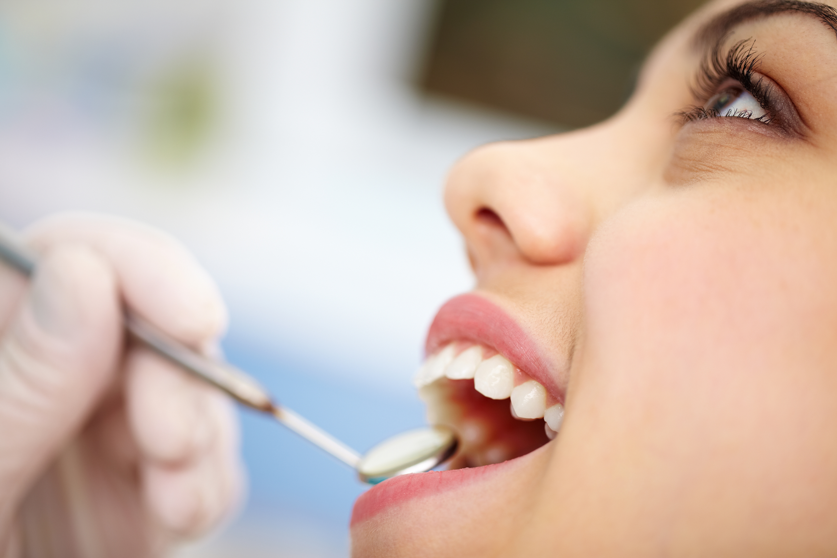 Junge Frau zeigt ihre Zähne in der Zahnarztpraxis